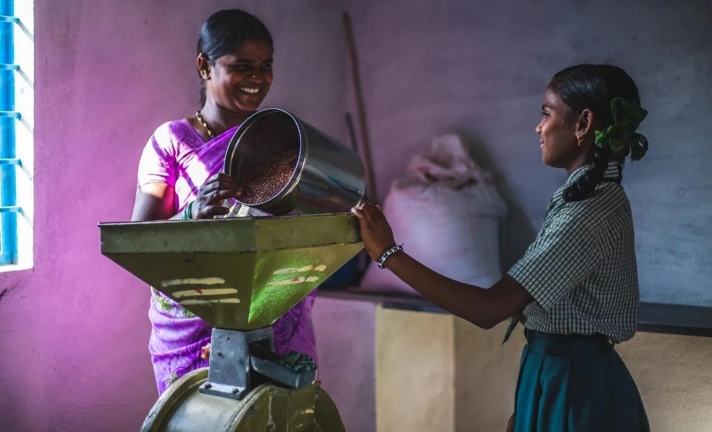 a woman and a girl processing food rural livelihood selco.jpg